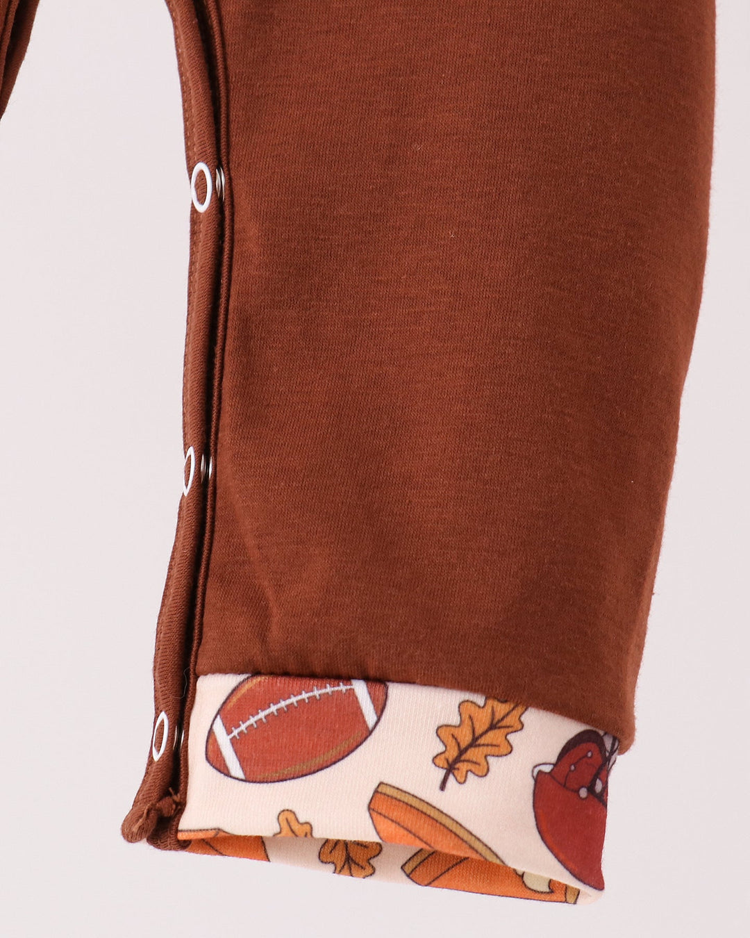 Brown romper leg with football-printed cuff detail at hem