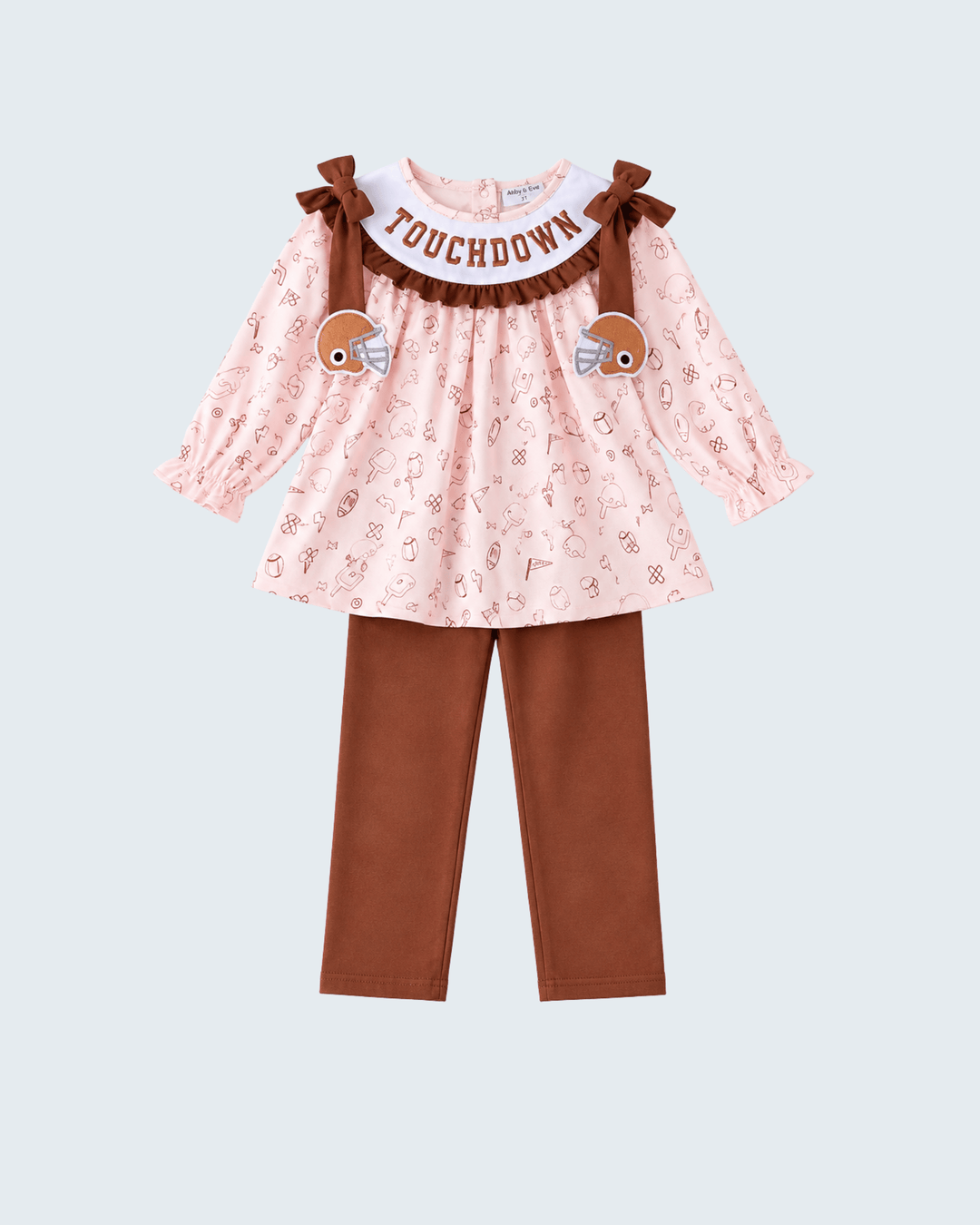 Girls ruffle top and brown pants set, pink football print with bow shoulders.