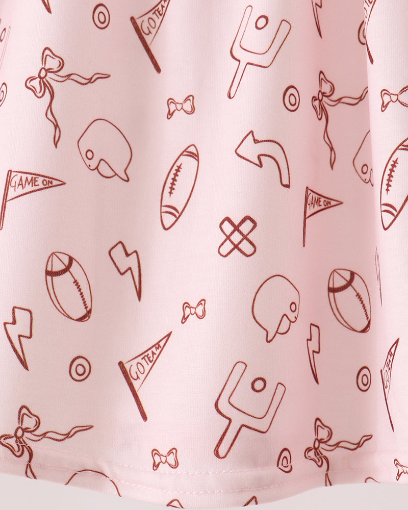 White skirt fabric with red sports icon pattern and ruffled hem, close-up