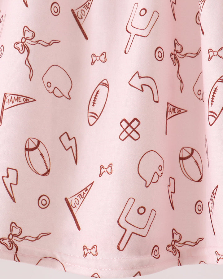 White skirt fabric with red sports icon pattern and ruffled hem, close-up