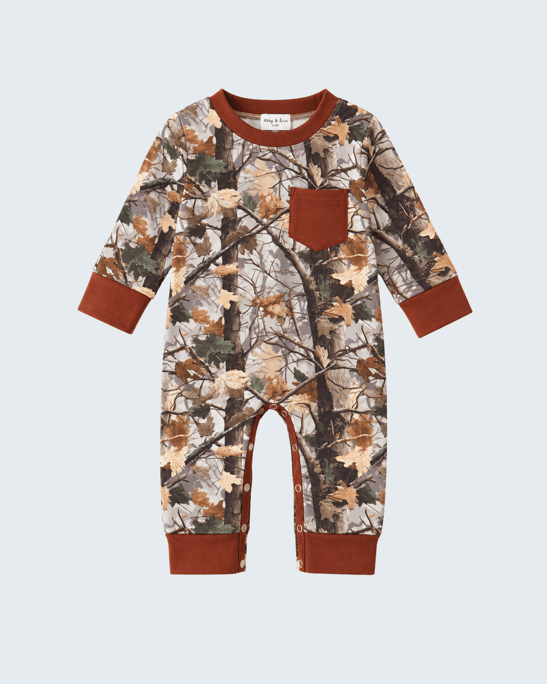 A baby long-sleeve footless jumpsuit featuring an autumn leaf and tree branch camouflage pattern, with solid rust-brown trim on the collar, cuffs, pocket, and leg openings.