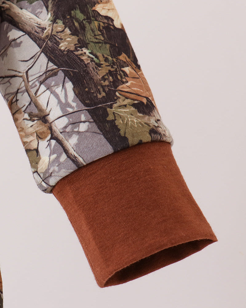 Sleeve end and leg cuff of tree-print romper, brown cuff at hem