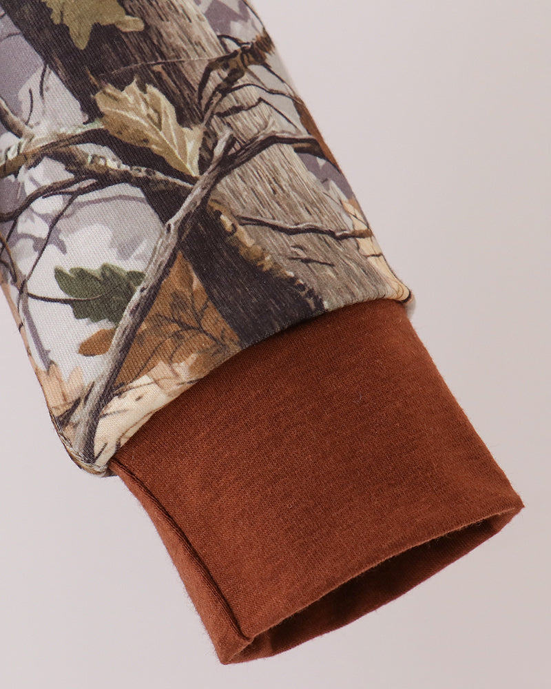 Tree-camouflage pullover sleeve with brown knit cuff and woodland print