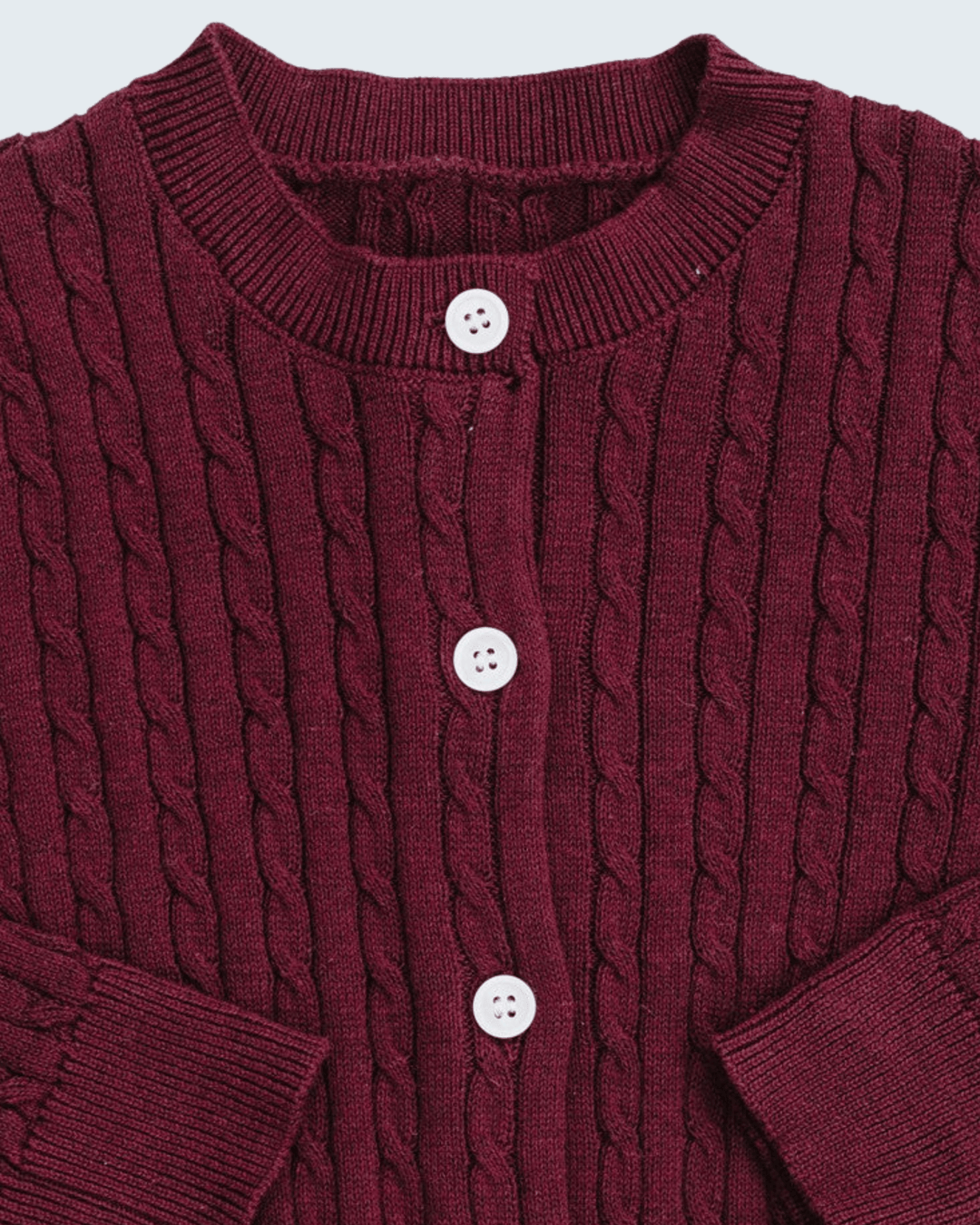 A close-up of a burgundy cable-knit cardigan sweater featuring a crew neck, three white buttons, and ribbed cuffs.