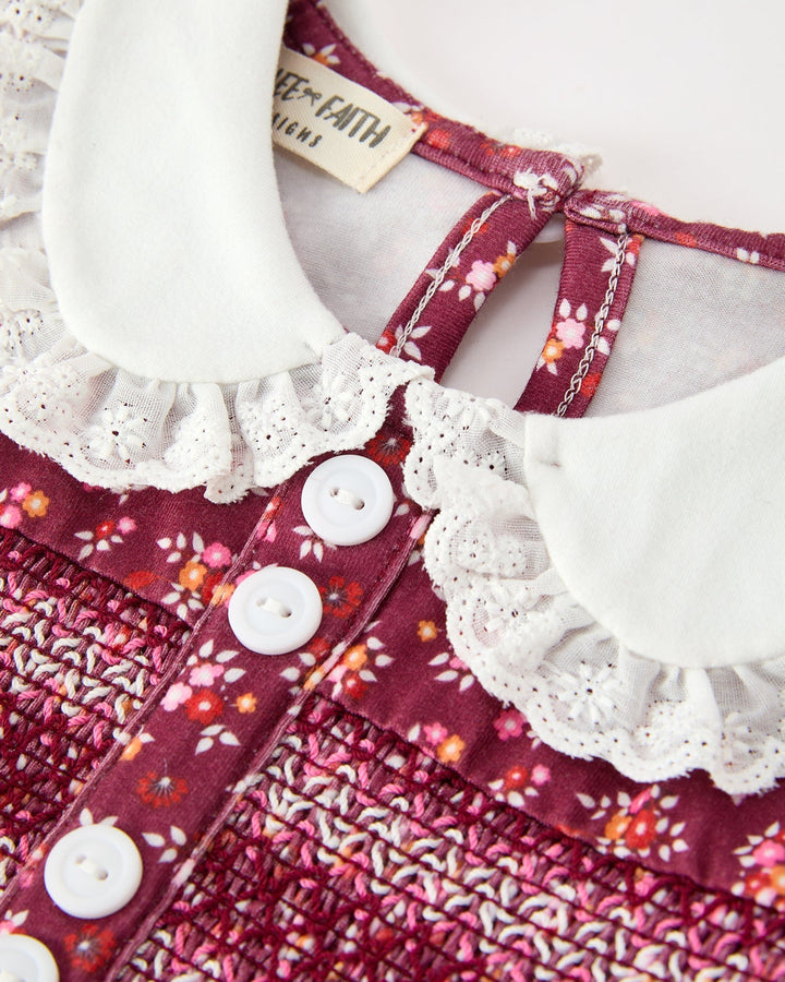 Close-up of burgundy floral bubble romper with white lace-trim Peter Pan collar and buttons