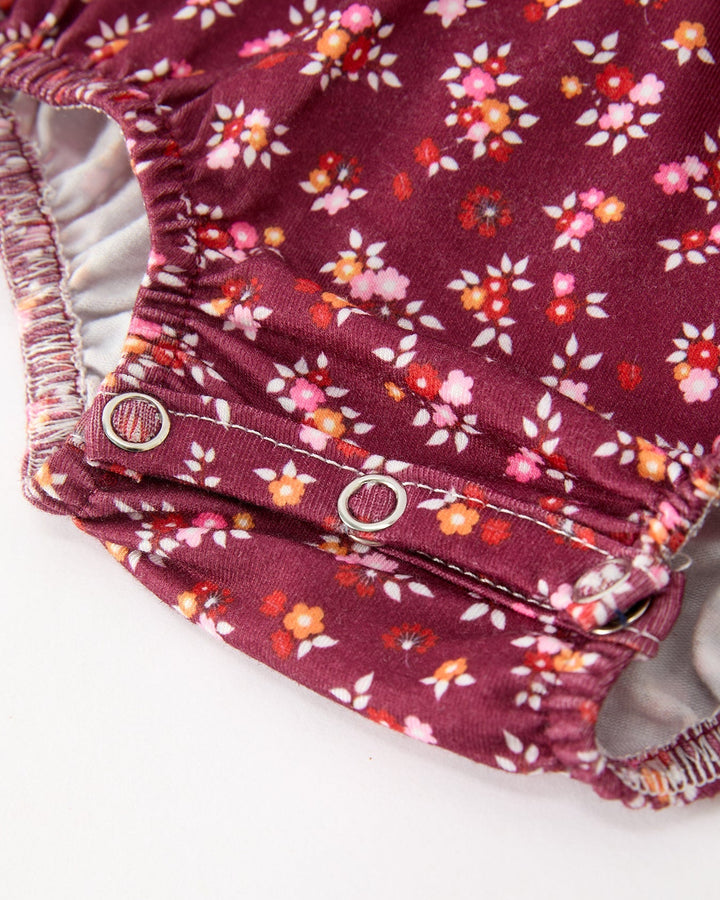 Burgundy floral bubble romper cuff with snap buttons and gathered smocked waist