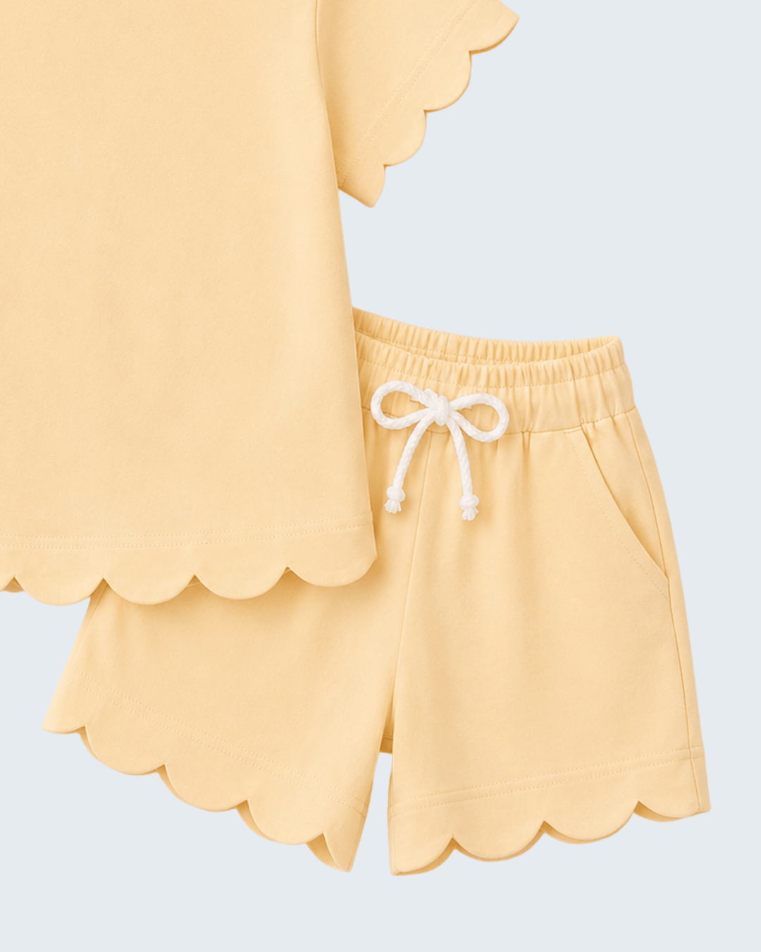 Yellow scalloped shorts with a white drawstring on a light blue background