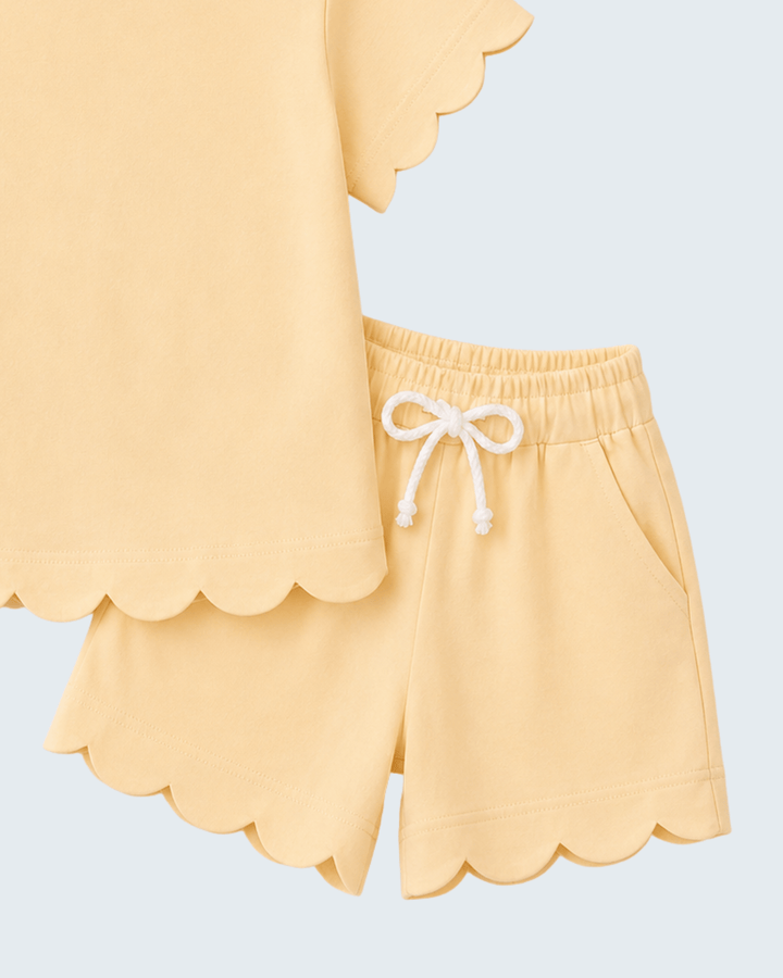 Yellow scalloped shorts with a white drawstring on a light blue background
