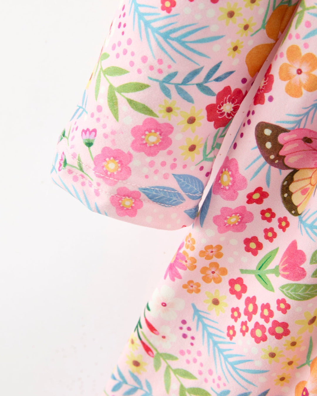 Floral fabric with pink flowers, green leaves, and orange butterflies on a white background