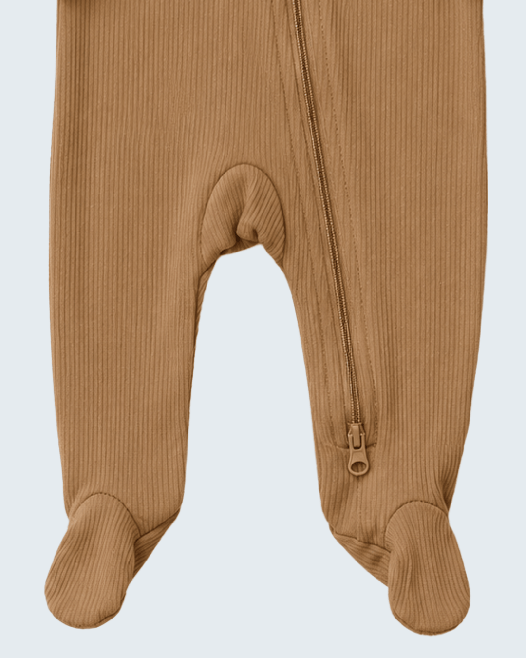 Close-up of a baby footed one-piece pajama in a warm camel brown ribbed fabric, showing the front zipper and foot cuffs against a light gray background.