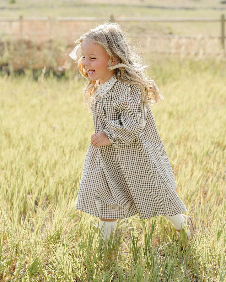 Gingham lace dress worn by child, long sleeves and lace-trim collar