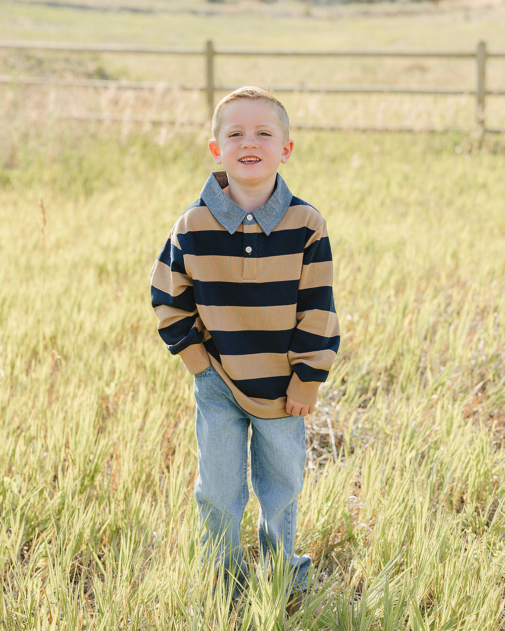 Kid wearing tan-and-navy striped polo shirt with chambray collar and button placket.