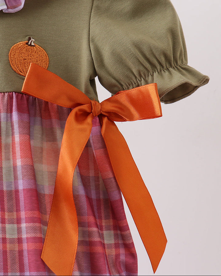 Plaid bubble romper with orange satin bow at waist and puff sleeves