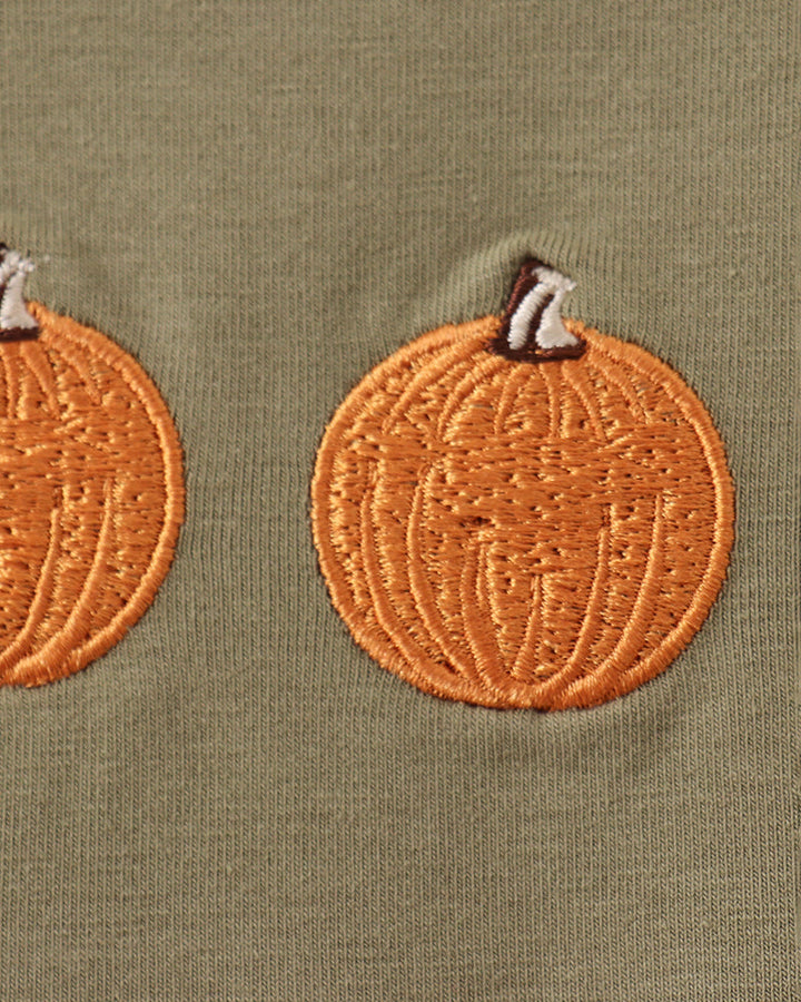 Green dress with orange pumpkin embroidery detail on chest