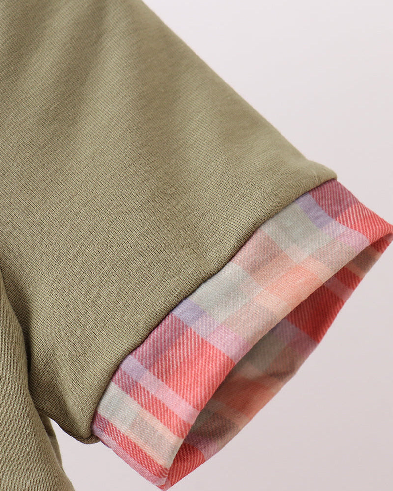 Olive green dress sleeve cuff with pink, red, and white plaid trim