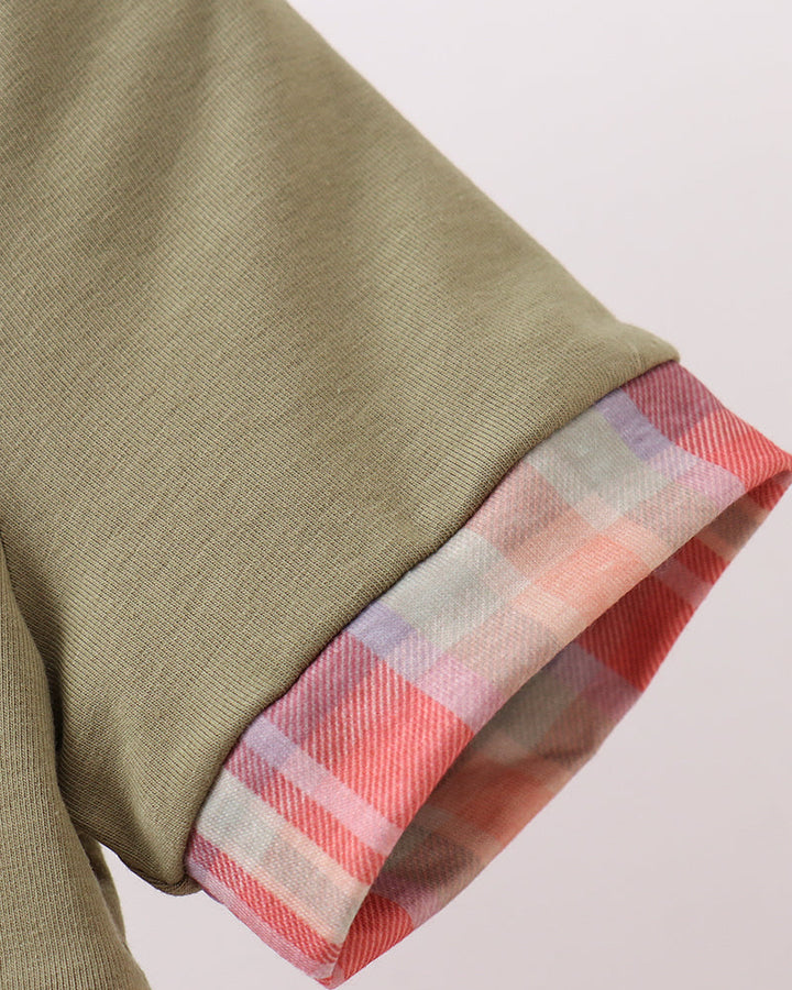 Olive green dress sleeve cuff with pink, red, and white plaid trim