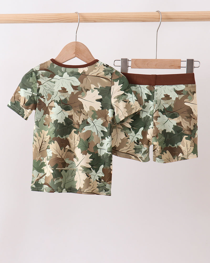 Camouflage-patterned shirt and shorts set on hangers against a white background