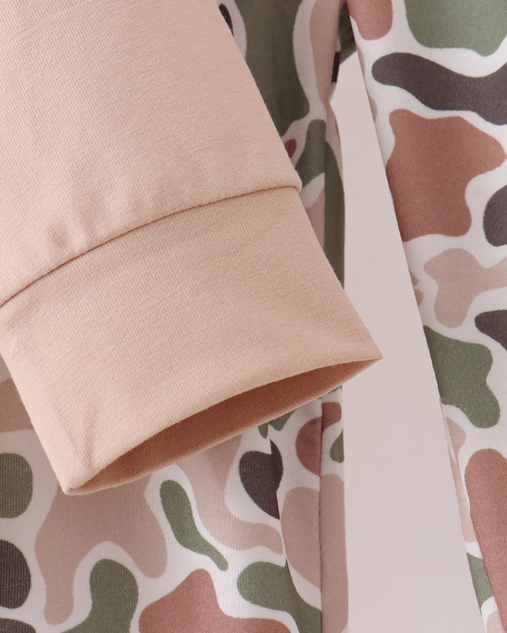 Beige sleeve cuff and matching camo pants side panel with stitched edge