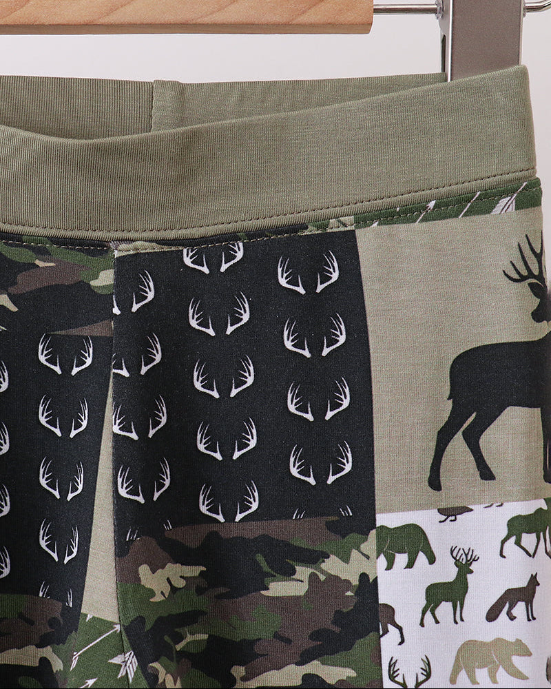 Kids pants with olive waistband and camo panel, deer and antler print detail