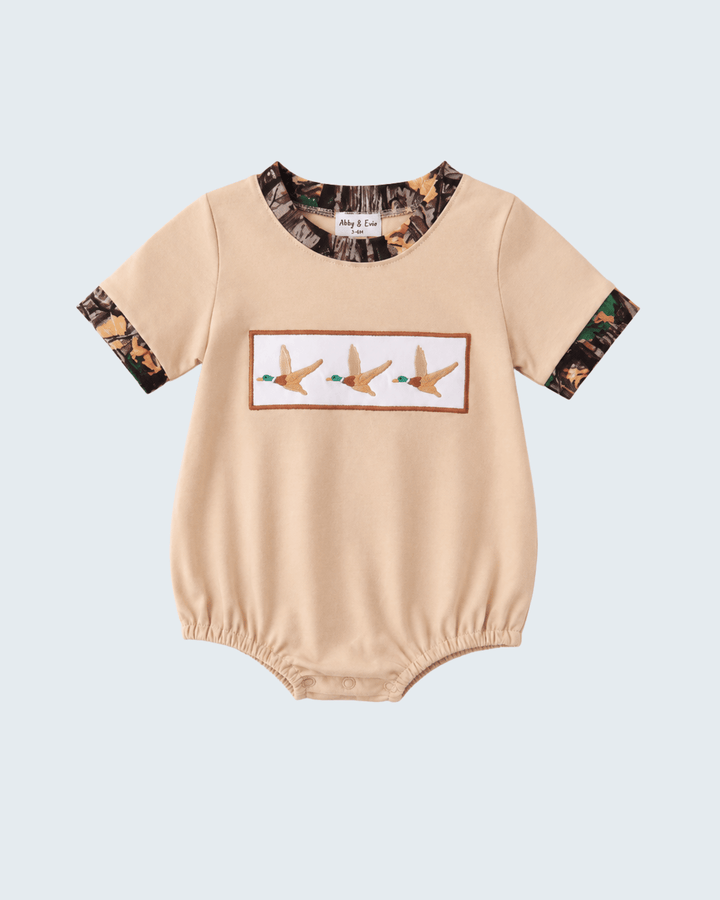 Beige baby romper with camouflage sleeves and duck design on a light blue background