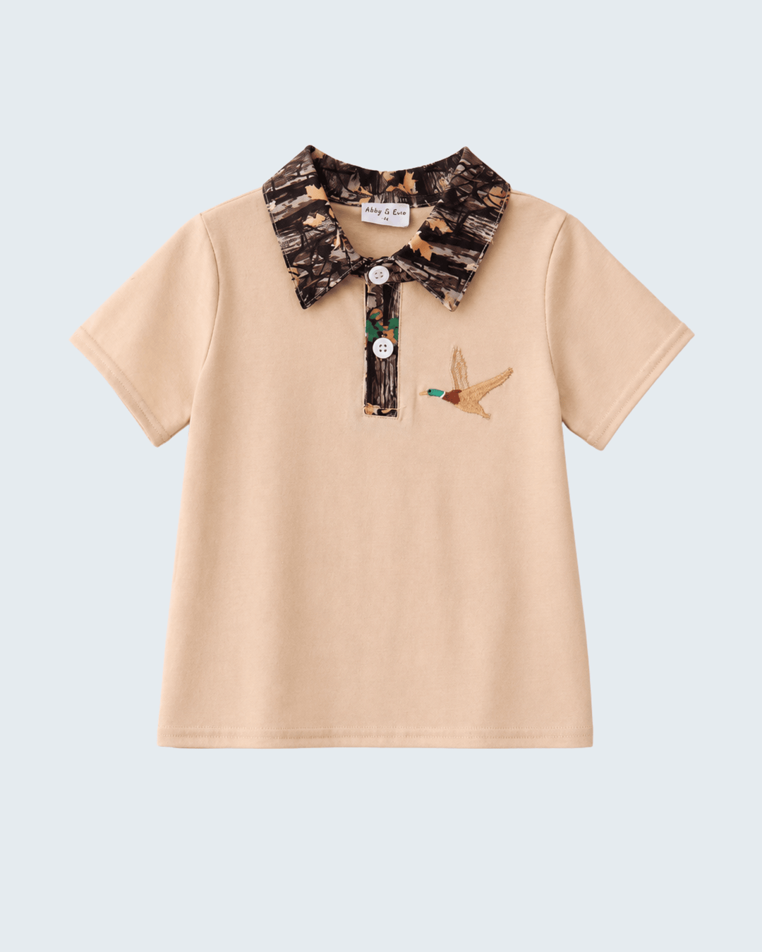 Beige polo shirt with camouflage collar and duck design on a light blue background