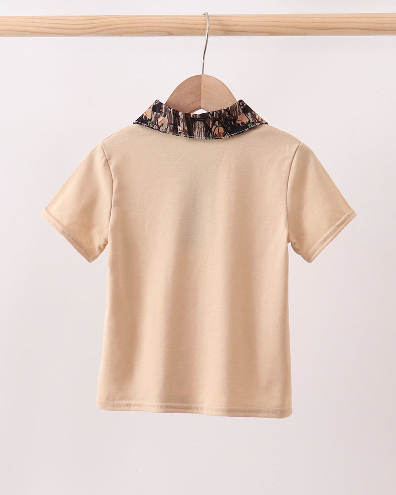 Beige shirt with floral collar on a wooden hanger against a white background