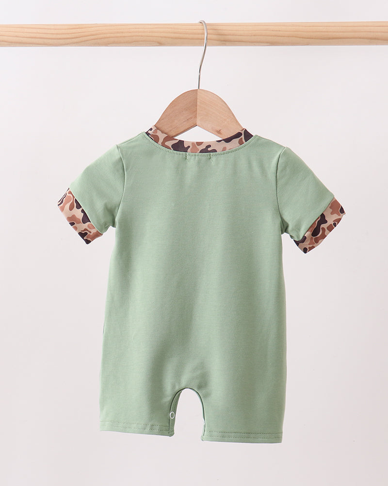 Green baby romper with floral sleeves on a wooden hanger against a white background