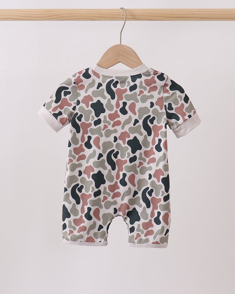 Camouflage-patterned baby romper on a hanger against a white background