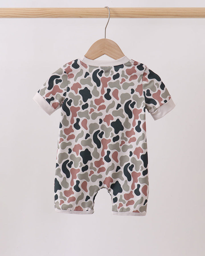 Camouflage-patterned baby romper on a hanger against a white background