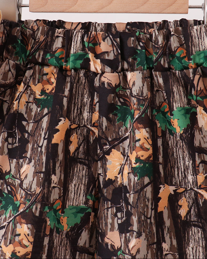 Camouflage-patterned fabric on a wooden hanger against a white background
