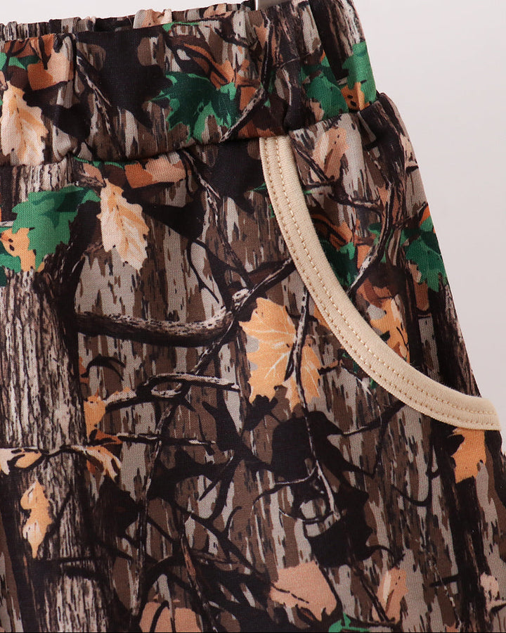 Camouflage-patterned shorts with drawstring on a hanger against a white background