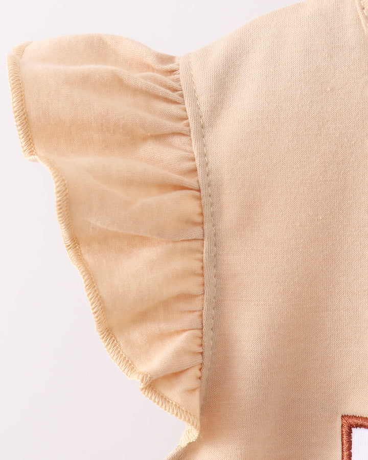 Close-up of beige fabric with ruffled edge on a light gray background