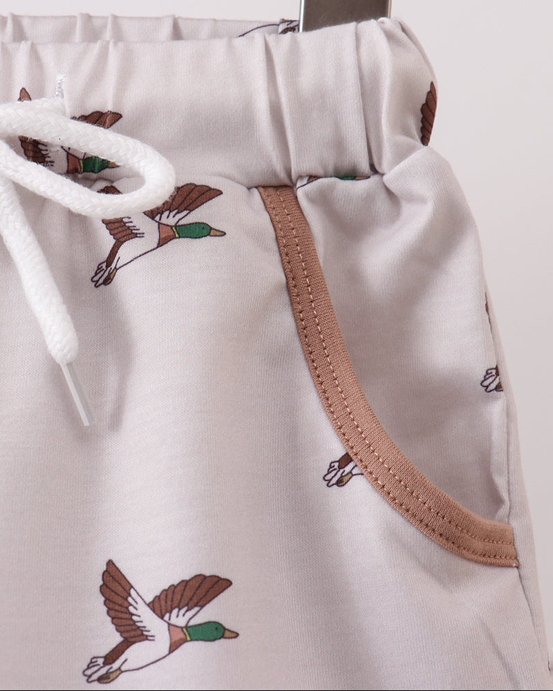 White shorts with bird illustrations on a wooden surface