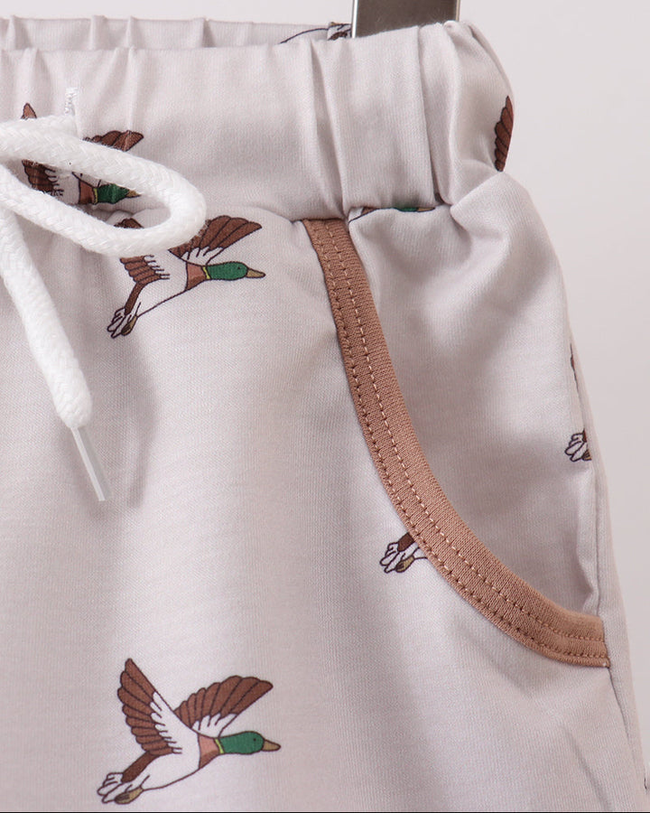 White shorts with bird illustrations on a wooden surface