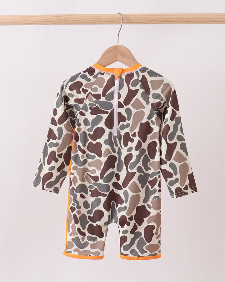 Camouflage-patterned swimsuit with orange trim on a wooden hanger against a white background