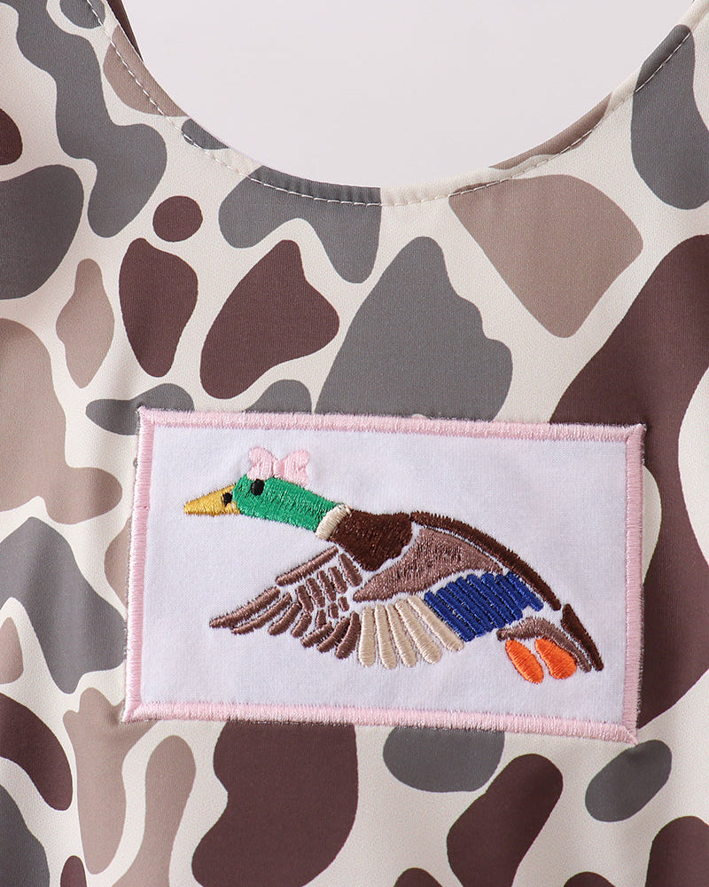 Embroidered patch of a duck on a camouflage-patterned fabric background