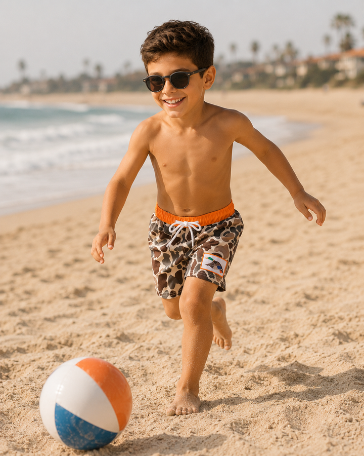 Child playing with a beach ball on a sandy beach