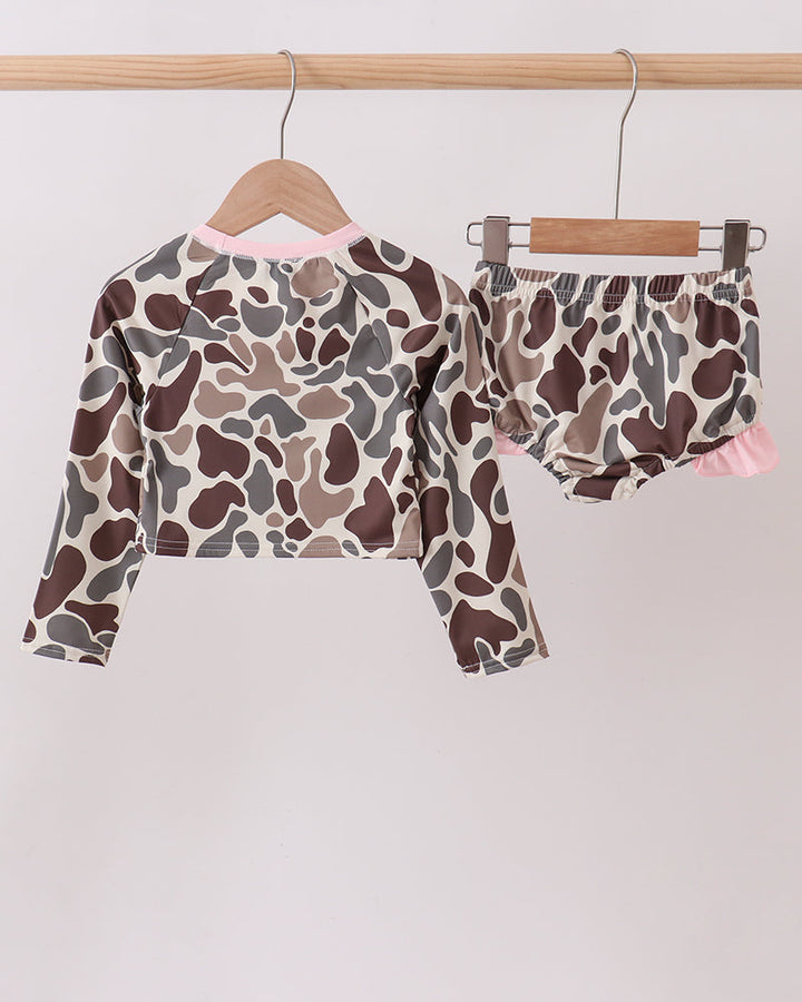 Camouflage-patterned rashguard set on hangers against a white background