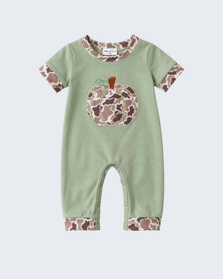 A baby short-sleeve romper in sage green, featuring a large applique pumpkin with a brown and beige camouflage pattern on the chest, matching camouflage trim on the collar and cuffs, and a camouflage pattern on the cuffed legs.