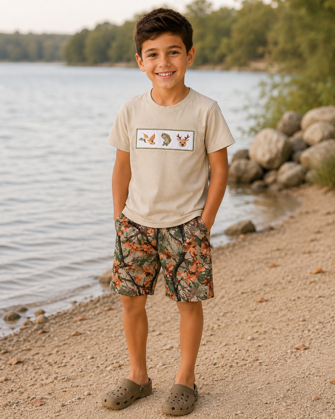 Young boy standing by a lake