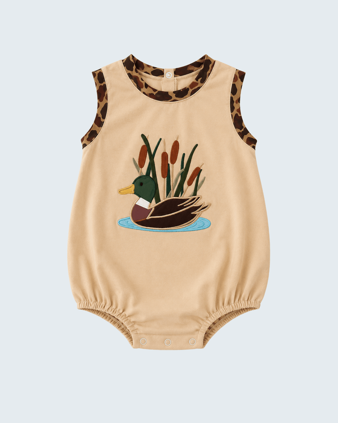 A sleeveless beige baby romper with a duck and cattails graphic on the front, leopard-print trim at the neckline and armholes, and snap closures at the crotch.