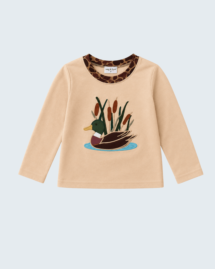 A beige long-sleeve t-shirt featuring a duck and reeds graphic on the chest and a leopard-print inner collar, shown against a light gray background.