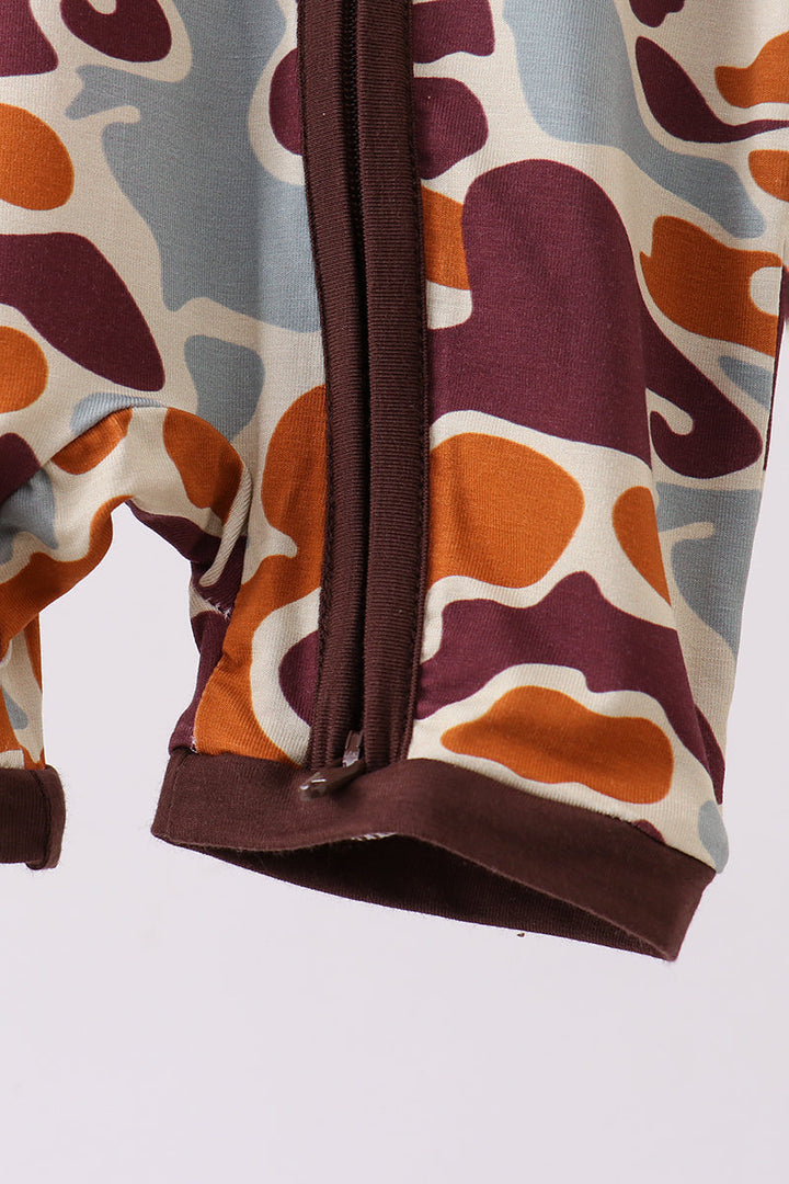 Close-up of a patterned fabric with brown, orange, and beige colors on a white background.