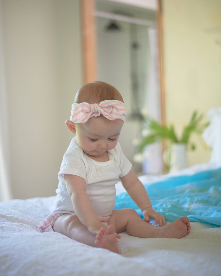 Baby bamboo bloomers with candy-striped ruffles and matching pink headband