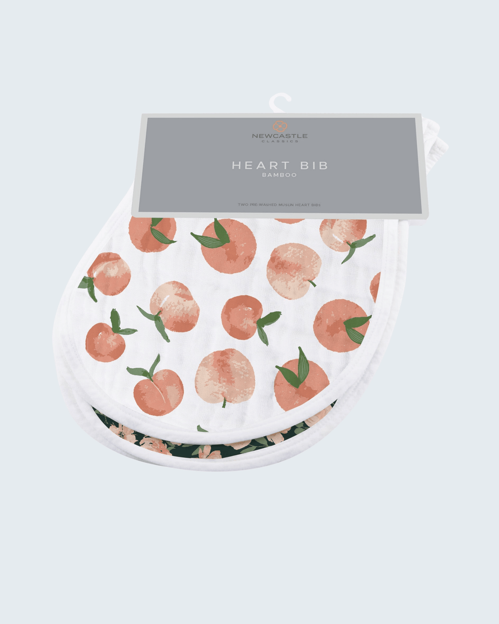 Heart-shaped bib with peach pattern on a light gray background
