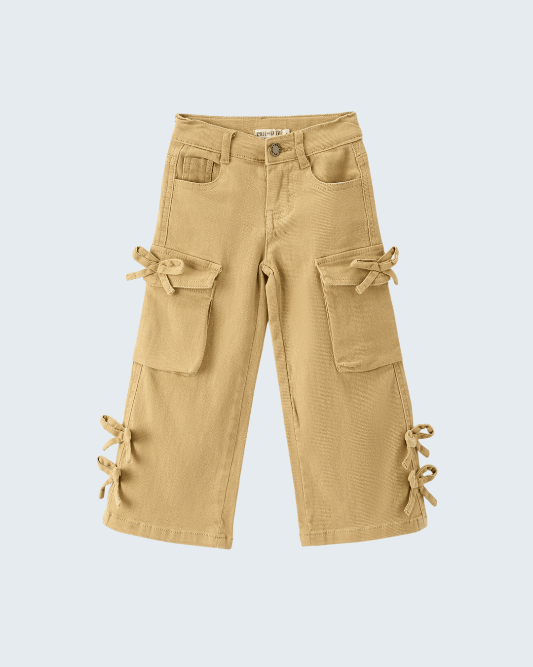 A pair of beige cargo pants for kids, featuring multiple utility pockets and decorative fabric tie details on the sides, shown against a light gray background.