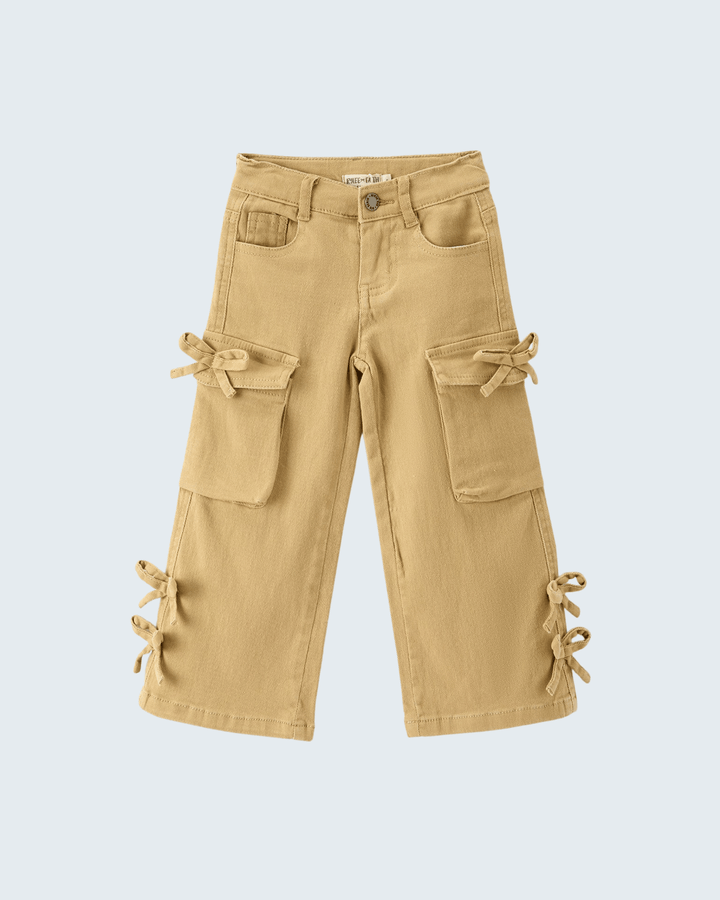 A pair of beige cargo pants for kids, featuring multiple utility pockets and decorative fabric tie details on the sides, shown against a light gray background.