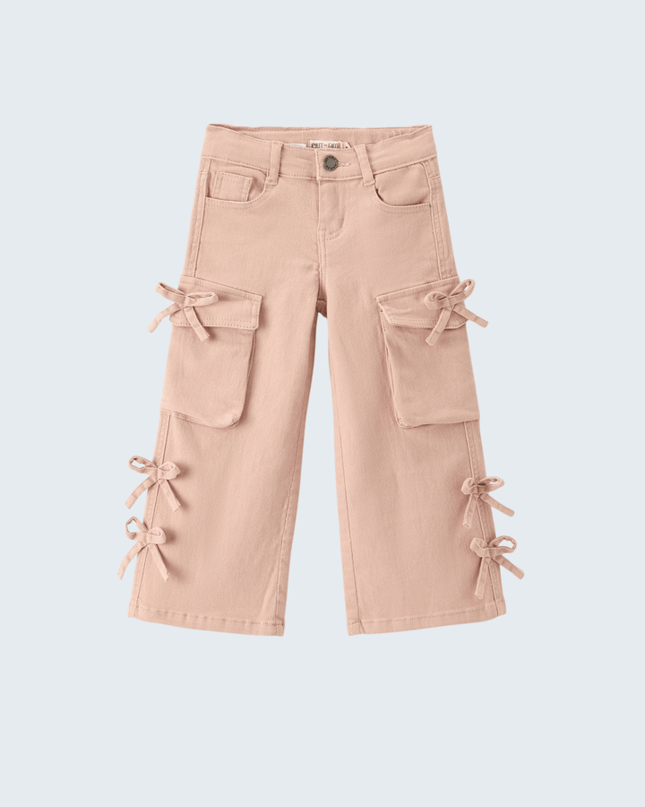 A pair of light pink cargo pants for kids, featuring multiple front pockets and decorative bow details tied at the knees and lower hems, shown against a light gray background.