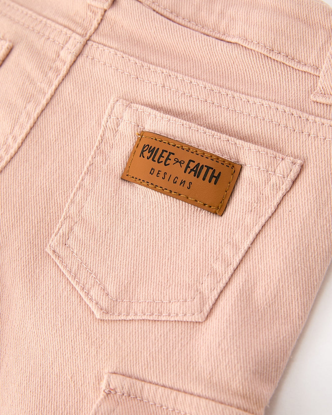 Light pink girls cargo pants with stitched pocket and leather brand patch