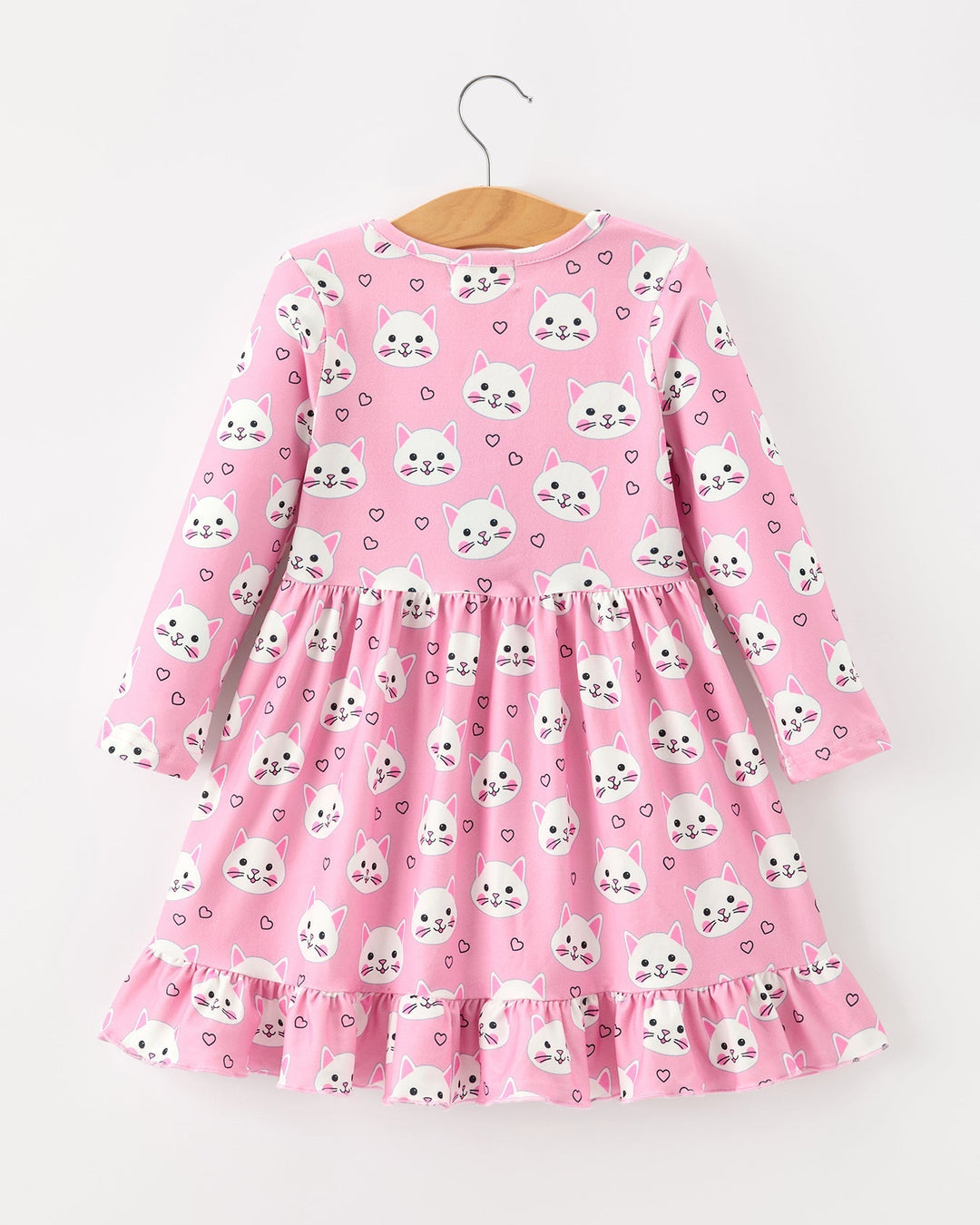 Pink dress with white animal print on a hanger against a white background